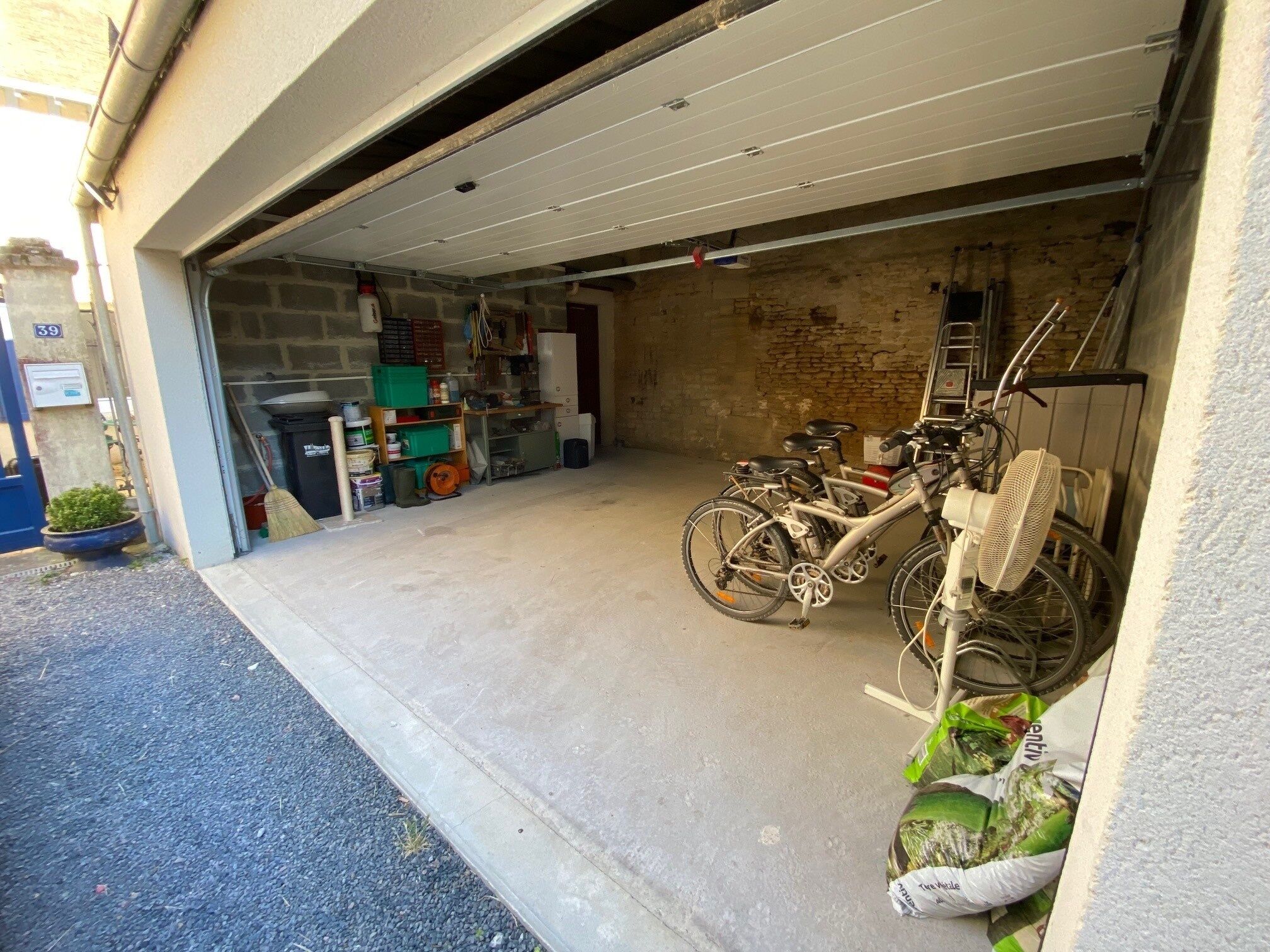 A garage with a bicycle and various items stored inside.
