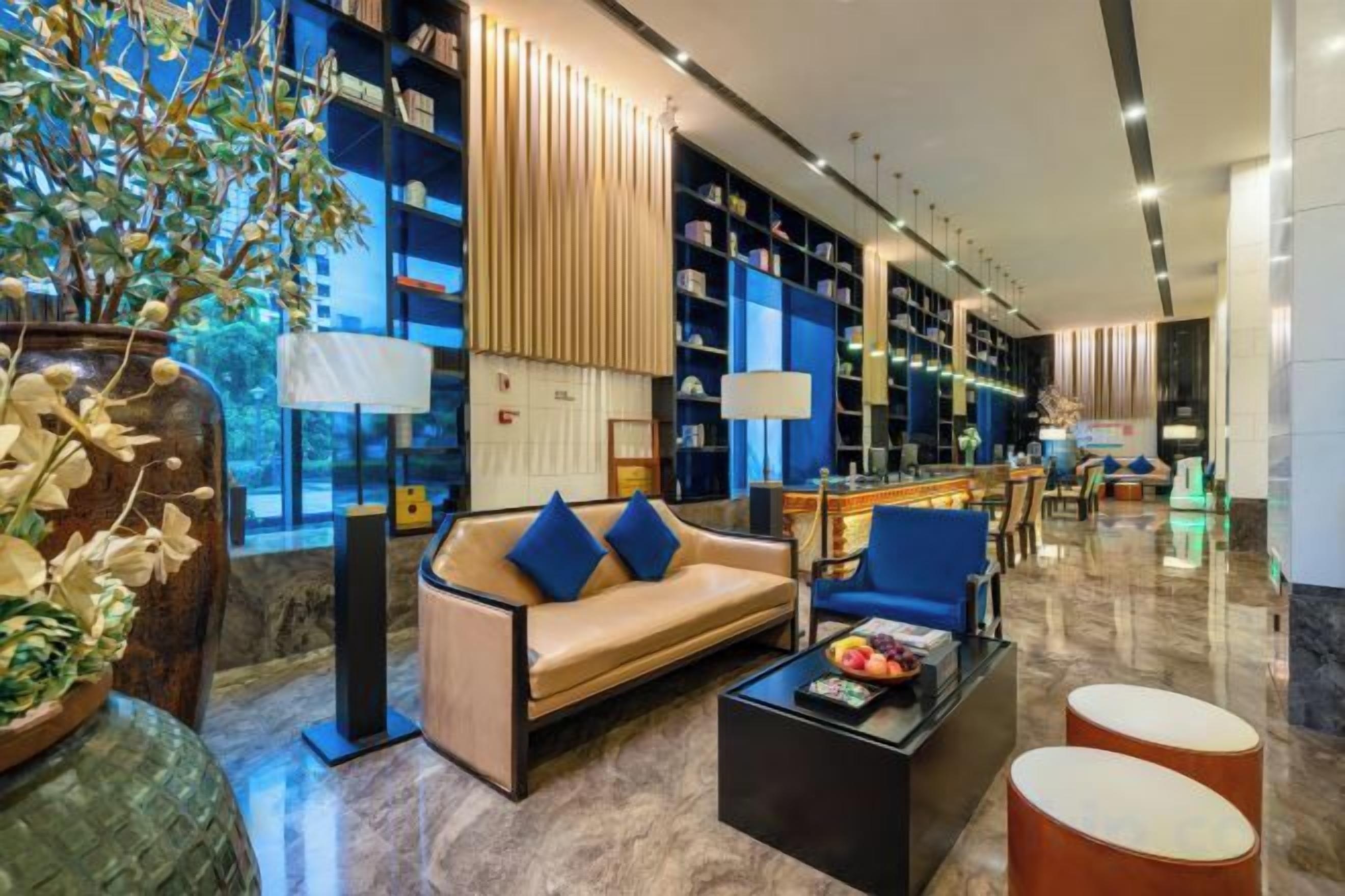 Eine moderne Lobby mit einer Couch, einem Couchtisch und Bücherregalen.