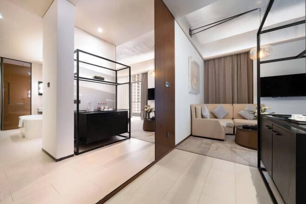 A modern living room with a sofa, coffee table, and a TV mounted on the wall.