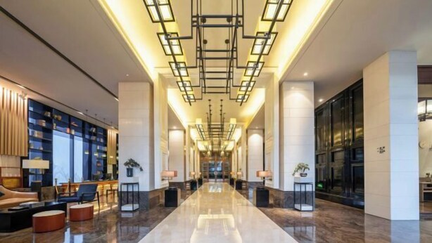 A spacious lobby with a polished marble floor, a central chandelier, and a seating area with sofas and tables. - Guigang Railway Station UEASY Hotel (Guigang)