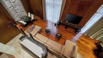 Una sala de estar moderna con un sofá modular, un televisor y un comedor con una mesa y sillas.