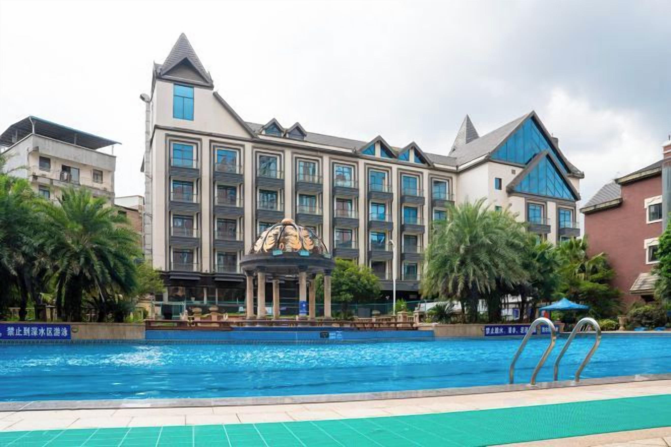 A hotel with a swimming pool, a gazebo, and a fountain.