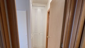 Um corredor com piso coberto de carpete, portas de madeira e uma luminária no teto.