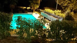 A swimming pool surrounded by lush greenery, with a covered area and seating. - Bright villa - Private pool - Near Pézenas (Valros)