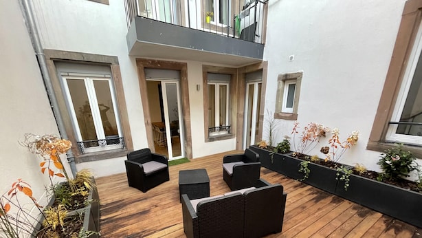A wooden deck with outdoor furniture, a planter with plants, and a view of the building's interior. - Newly renovated apartment, a stone's throw from town center and station (Strasbourg)