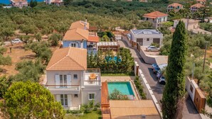 A residential area with houses, a swimming pool, and a view of the sea. - Oresteia Executive Villa, a Flamboyant Retreat (Tragaki)