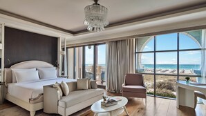 A spacious bedroom with a large bed, a sofa, a coffee table, and a view of the beach. - Club Privé by Rixos Saadiyat Island (Abu Dhabi)