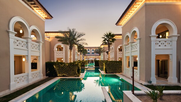 A pool area with a clear view of the pool, surrounded by buildings with arched windows and a tiled roof. - Club Privé by Rixos Saadiyat Island (Abu Dhabi)