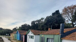 A row of small, colorful wooden cabins with a dirt path leading to them.