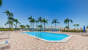 A swimming pool with lounge chairs and palm trees. - Waterview 1BR condo with pool, hot tub, and balcony in St. Petersburg. (St Petersburg)
