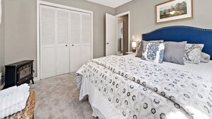 A bedroom with a large bed, a wardrobe, a heater, and a framed picture on the wall.