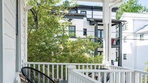 A covered porch with a white railing, a black metal chair, and a small table. - Downtown Charmer! 3BD/3BA - 2 Blocks to King (Charleston)