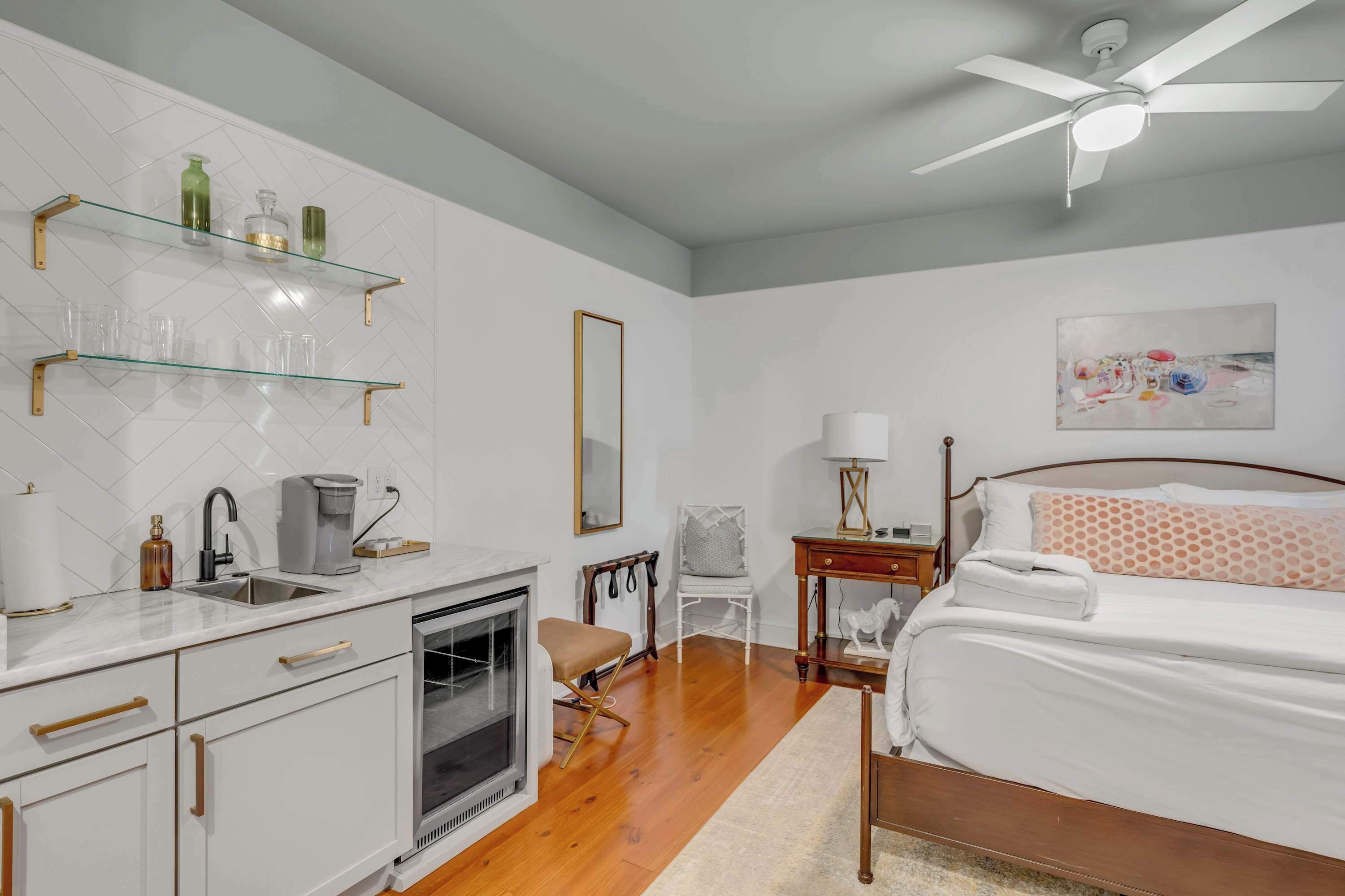 A modern bedroom with a bed, bedside table, and a painting on the wall.