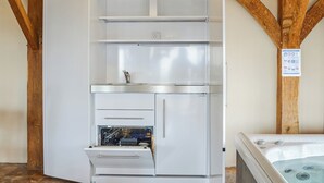 Une chambre d’angle équipée d’un lave-vaisselle encastré, d’un petit évier et d’un jacuzzi.