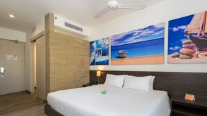 Une chambre d’hôtel avec un grand lit, une tête de lit en bois et un mur décoré d’œuvres d’art sur le thème de la marine.