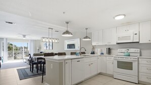 Een moderne keuken met witte kasten, een centraal eiland en een inbouwoven.