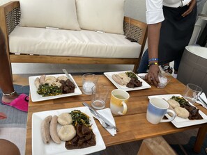 A dining table with plates of food, glasses, and cutlery. - Modern Villa with private backyard pool (Drax hall)