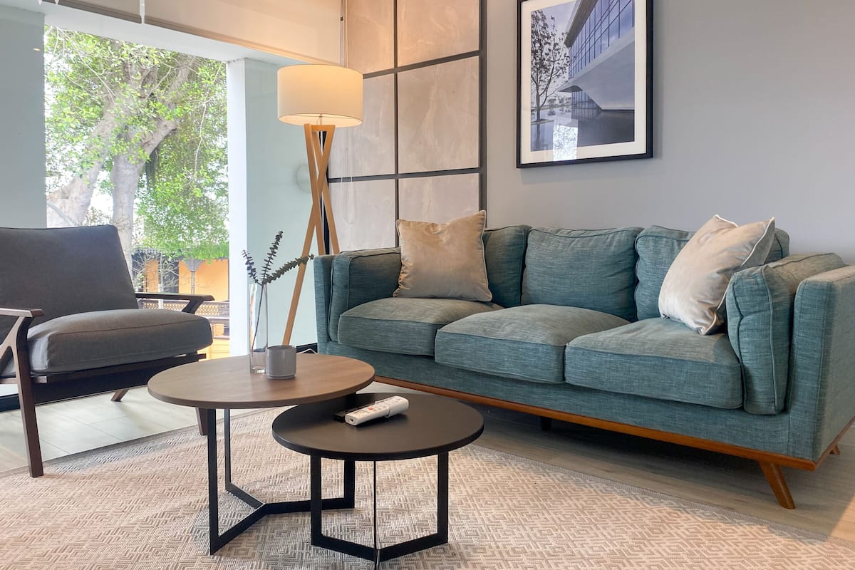 A modern living room with a grey sofa, a round coffee table, and a floor lamp.