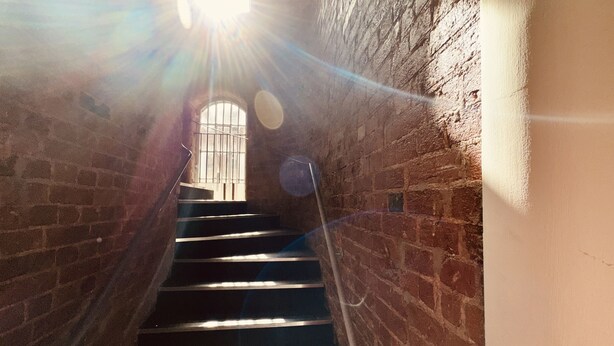 A staircase in a building with brick walls and a metal railing. - Lovely Studio Apartment in the Heart of Nottingham (Nottingham)