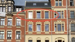 Una fila di edifici a più piani con diversi stili architettonici, incluso un edificio d'angolo con una torretta.