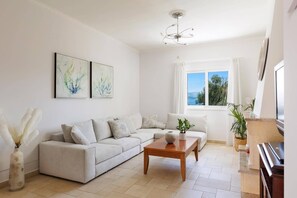 Ein modernes Wohnzimmer mit einer Couch, einem Couchtisch und Kunstwerken an der Wand.