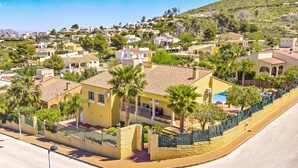 A residential area with houses, palm trees, and a curved road. - Villa Magdalena Blanca by Villa Plus (Jávea)
