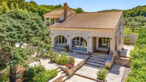 Una casa in pietra con tetto in tegole, finestre ad arco e una scala in pietra che conduce all'ingresso.