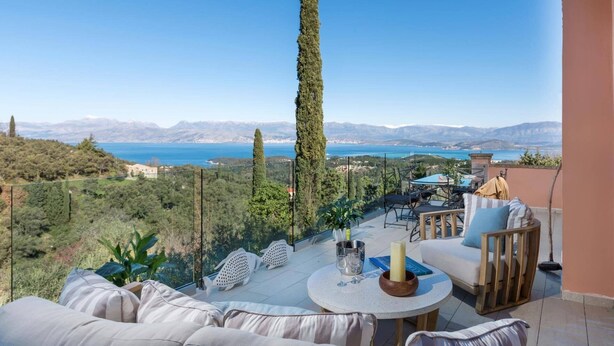 A terrace with a view of a lake and mountains, furnished with a sofa, chairs, and a table. - Villa Kalliopi by Villa Plus (Kokkini)