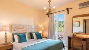 A bedroom with a large bed, two bedside tables with lamps, a dresser, a chair, and a balcony with a view. - Villa Kalliopi by Villa Plus (Kokkini)