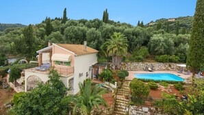 A villa with a swimming pool, surrounded by lush greenery and tall trees. - Villa Kerkyra by Villa Plus (Άγιος Στέφανος)