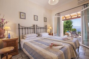 Quarto com cama, mesas de cabeceira, vista para o exterior e uma janela.