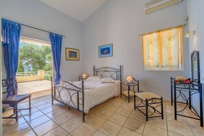 A bedroom with a bed, bedside tables, a chair, a desk, and a window with curtains.