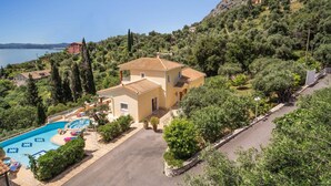 En toetagers bygning med swimmingpool og have.