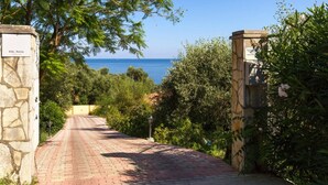 Un sendero pavimentado que lleva a una puerta con vista al mar.