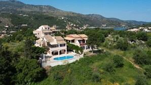 Una villa costiera con piscina, immersa nel verde e con vista su una baia.