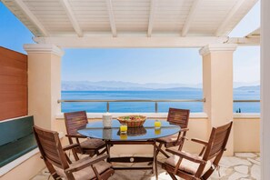 A table with chairs and a view of the sea.