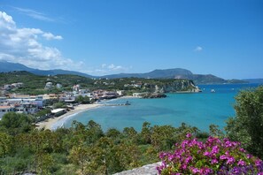 A coastal town with a beach, clear blue sea, and mountains in the background. - Villa Almyrida View by Villa Plus (Apokoronos)