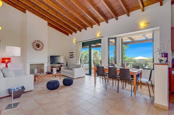 A spacious living area with a fireplace, a television, and a dining area with a view.