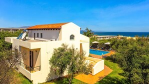 En modern villa med en swimmingpool, en terrass och utsikt över havet.