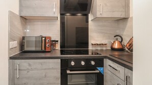 Uma cozinha moderna com forno embutido, micro-ondas e máquina de café.