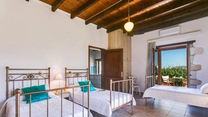 Un dormitorio con dos camas, techo de madera y vistas al exterior.