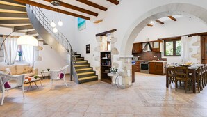 Un área de estar amplia con una escalera, una cocina y un comedor.