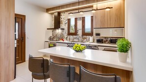 A modern kitchen with a large island, wooden cabinets, and a view of the outdoors.