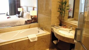 A hotel bathroom with a bathtub, sink, and mirror. - Lisan Garden Hotel (Ruichang)