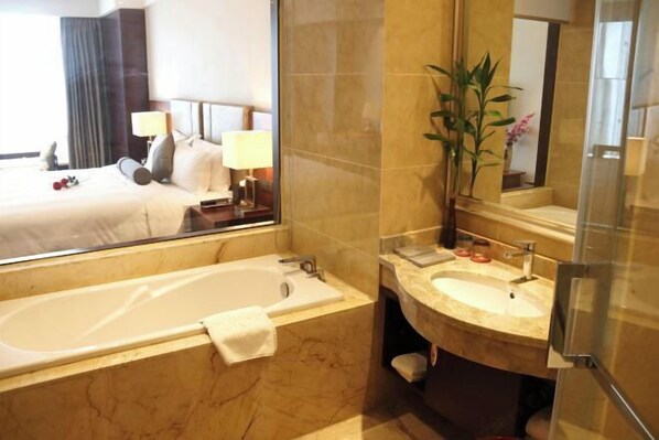 Ein Badezimmer mit Badewanne, Waschbecken und Spiegel.