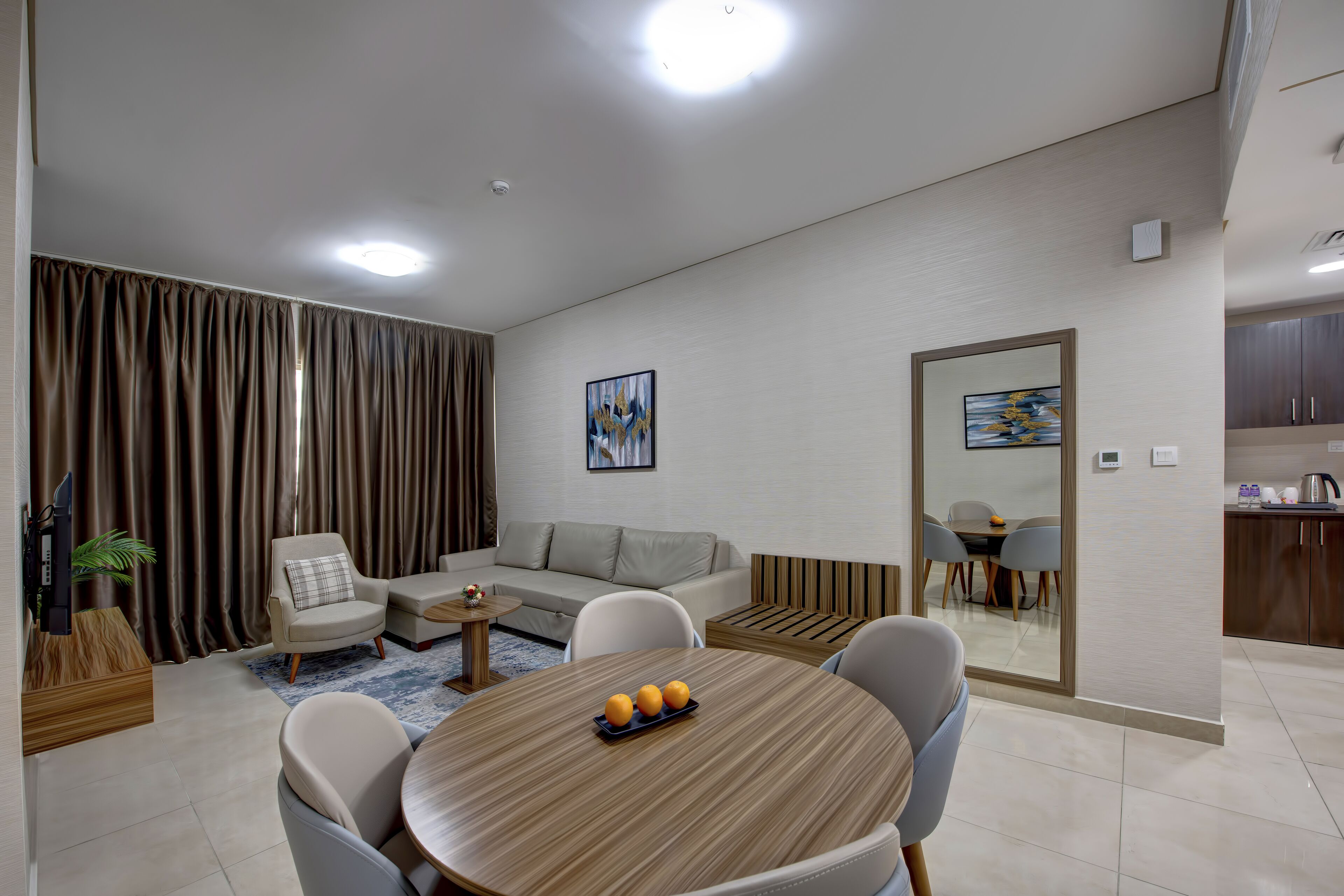 Una sala de estar moderna con una mesa redonda de madera, un sofá y un comedor.