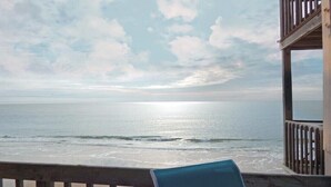 A beach view from a wooden deck with a chair. - Steps to the Beach! Just “Wait-N-Sea” what this condo has to offer! (North Topsail Beach)
