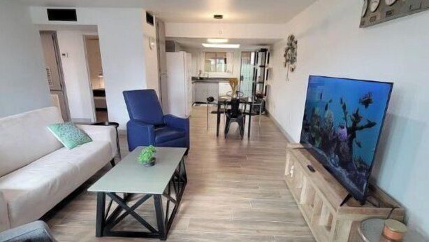A modern living room with a sofa, two armchairs, a coffee table, and a TV on a wooden stand. - Msg for 5%off_2Bed1Bath KingQueenBeds NorthPHX (Phoenix)