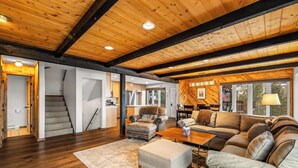 A spacious living room with a wooden ceiling, a large couch, a coffee table, and a rug. - Private Hot Tub! Close to Slopes! On Free Shuttle Route! (Steamboat Springs)