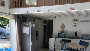 Una cocina moderna con comedor, refrigerador, microondas y lavaplatos.